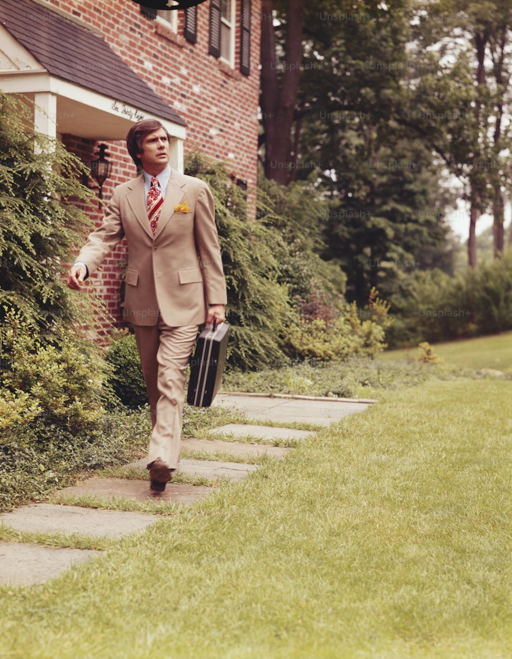 UNITED STATES - CIRCA 1970s:  Salesman walking outdoors, on way to work.