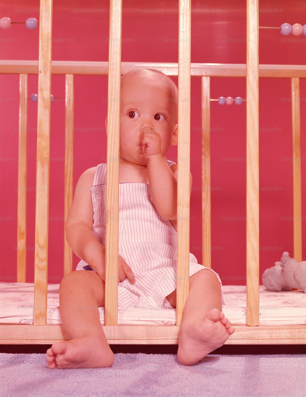 ESTADOS UNIDOS - Alrededor de la década de 1950: Bebé en corralito, chupándose el dedo.