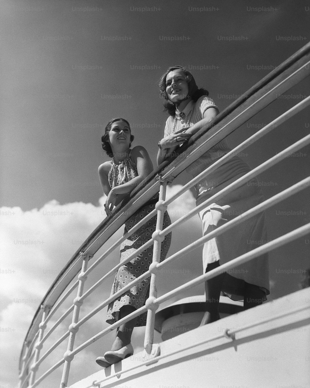 ESTADOS UNIDOS - CIRCA 1930: Dos mujeres de pie junto a la baranda en un crucero.