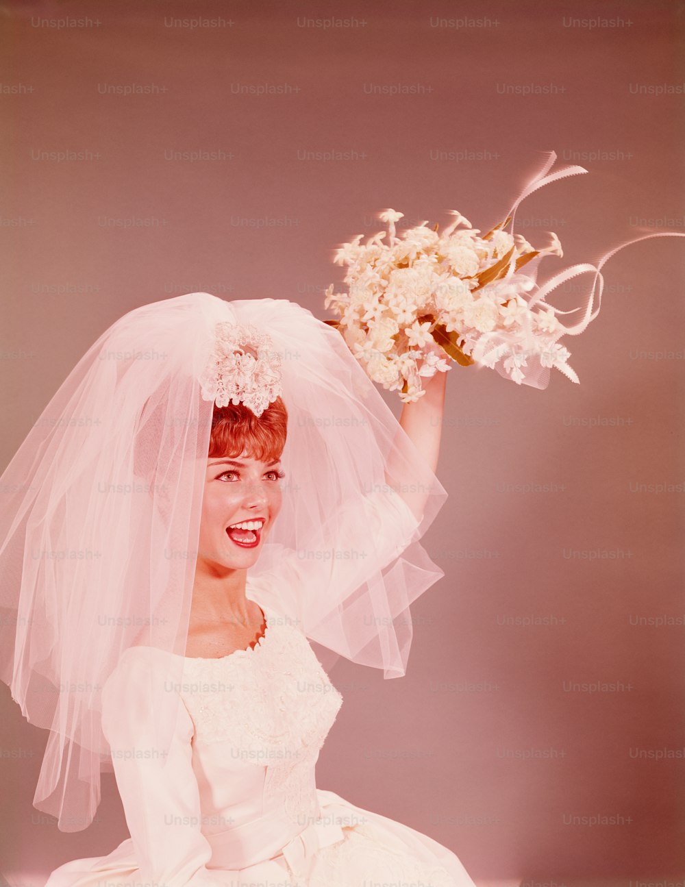 UNITED STATES - CIRCA 1950s:  Bride preparing to throw flower bouquet.