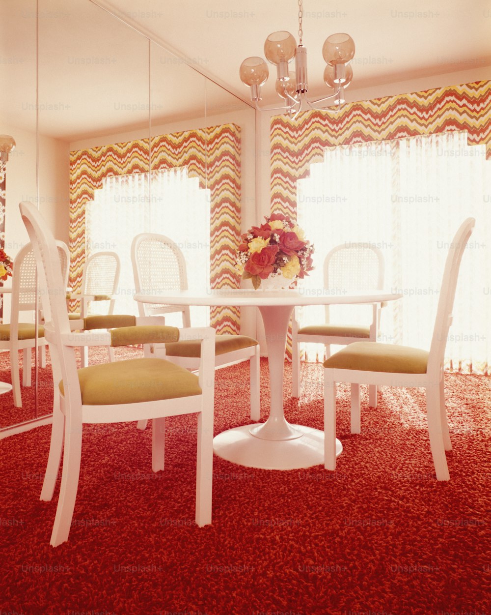 ÉTATS-UNIS - Vers les années 1970 : Intérieur de la salle à manger, avec table blanche et quatre guéridons en plastique moulé.