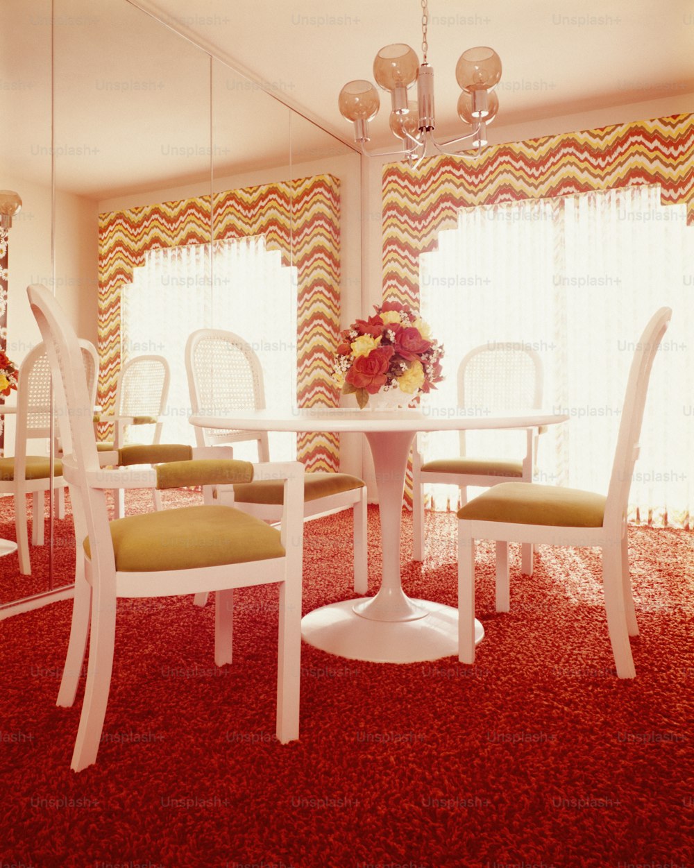 UNITED STATES - CIRCA 1970s:  Dining room interior, with white table and four moulded plastic pedestal chairs.