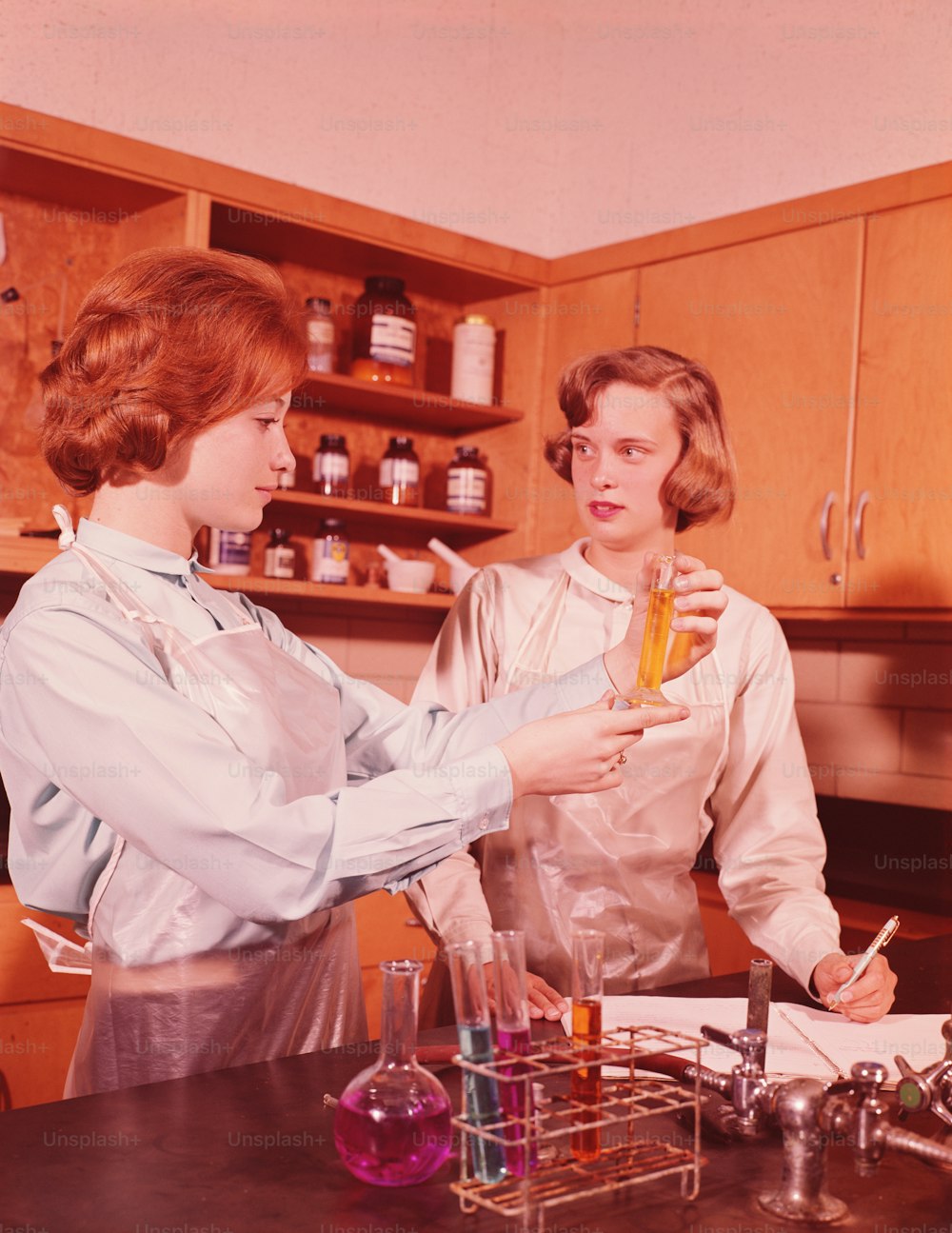 미국 - 1960년대경: 고등학교 화학 수업에서 화학 실험을 수행하는 두 명의 십대 젊은 여성. 사진 – Unsplash의 인원수 이미지