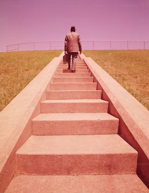 UNITED STATES - CIRCA 1960s:  Salesman climbing long flight of stone steps, rear view.
