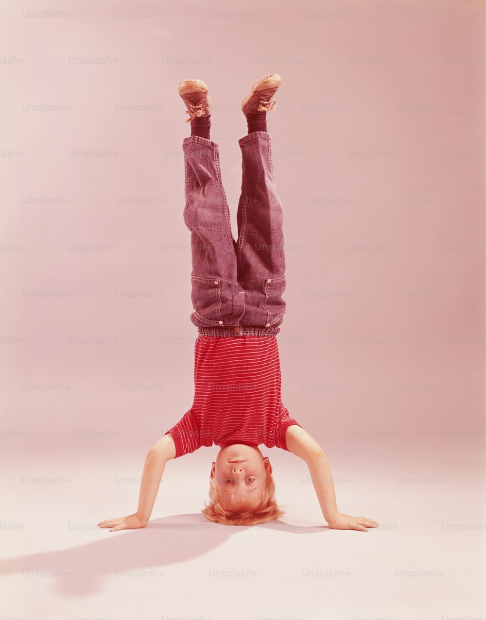 ESTADOS UNIDOS - CIRCA 1960s: Niño haciendo parada de cabeza de tres puntos.