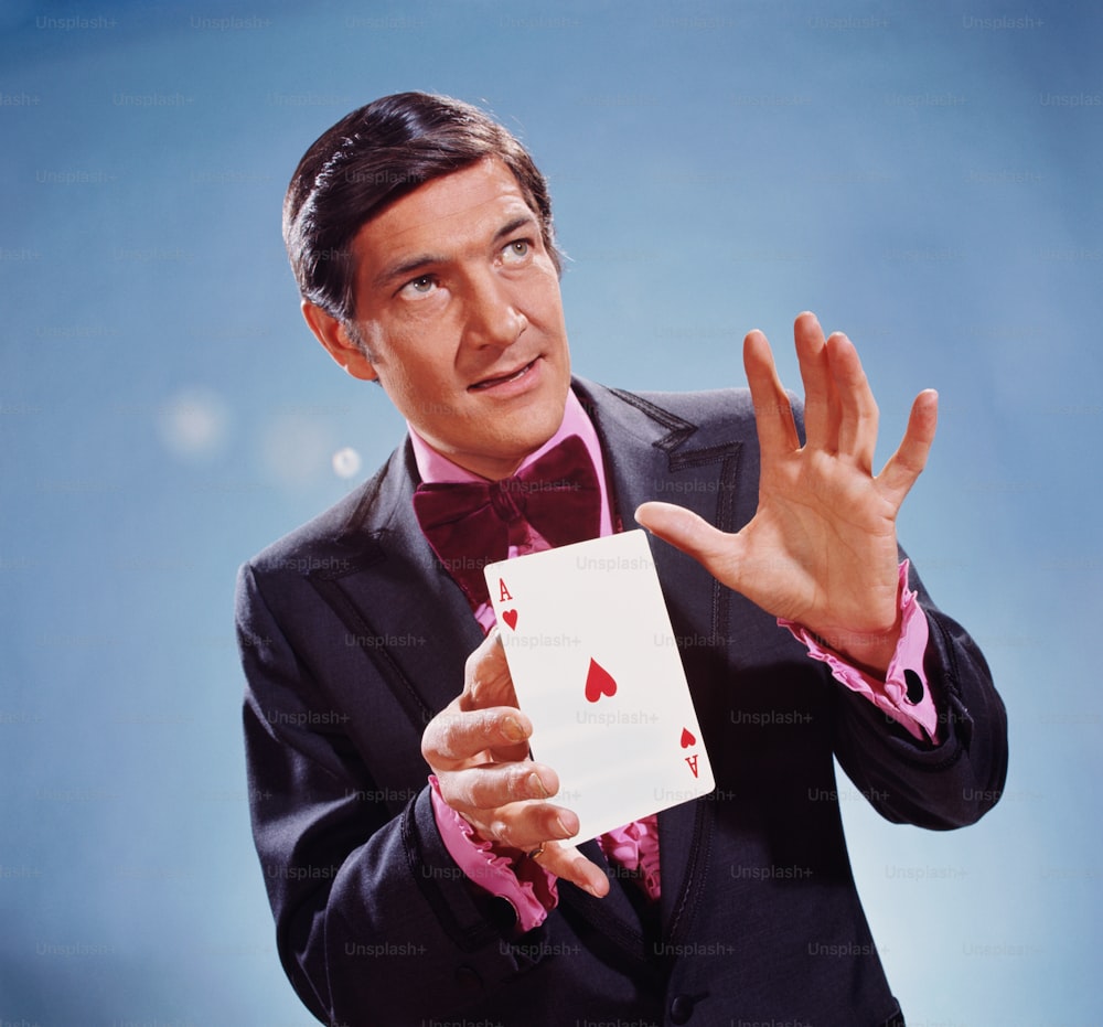 UNITED STATES - CIRCA 1970s:  Magician holding oversize ace of hearts in his hands.