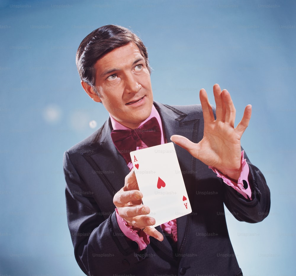 미국 - 1970년대경: 마술사가 대형 하트 에이스를 손에 들고 있다.