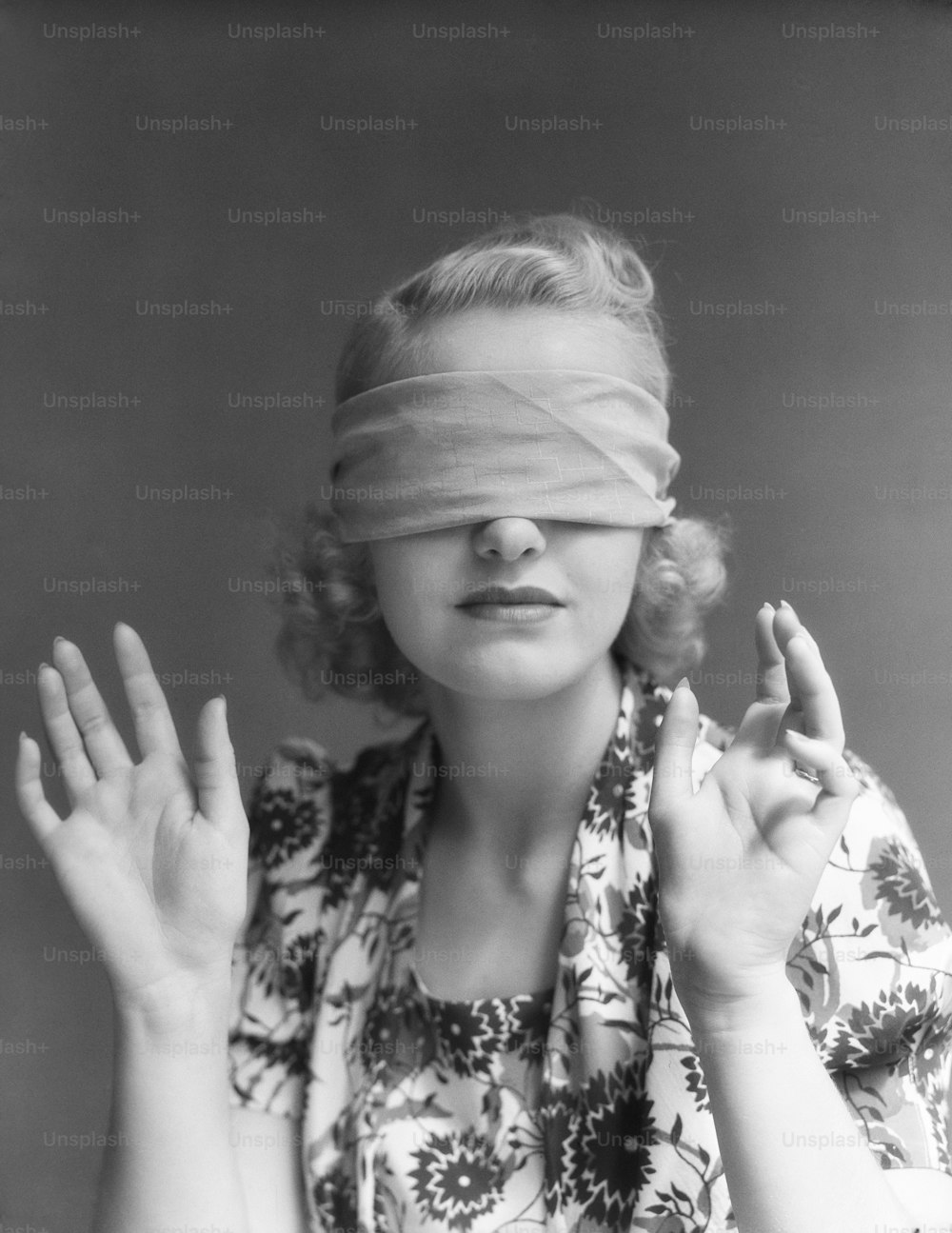 UNITED STATES - CIRCA 1930s:  Blindfolded woman holding hands out in front of herself.