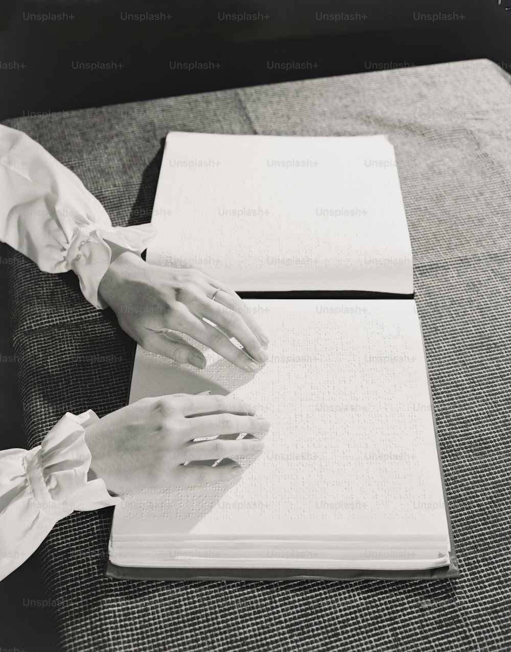 UNITED STATES - CIRCA 1940s:  Woman's hands reading Braille book on table.