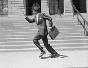 UNITED STATES - CIRCA 1950s:  Man carrying briefcase, running past stairs, low section.