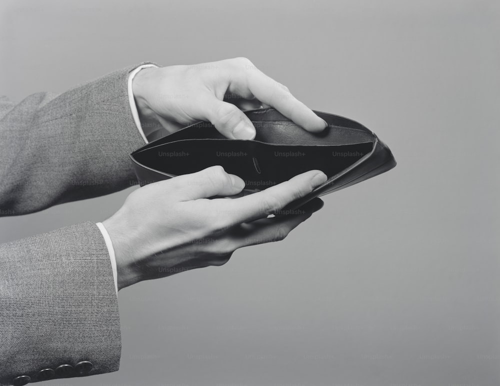 STATI UNITI - 1950 CIRCA: mani dell'uomo che tengono aperto il portafoglio vuoto.