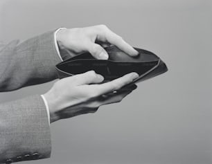 ESTADOS UNIDOS - CIRCA 1950s: Manos de hombre sosteniendo una billetera vacía abierta.