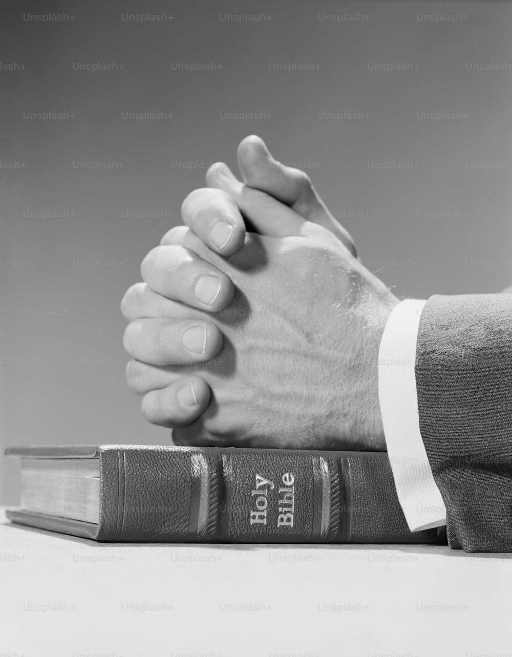 VEREINIGTE STAATEN - CIRCA 1960er Jahre: Die Hände des Mannes ruhen im Gebet auf der heiligen Bibel.