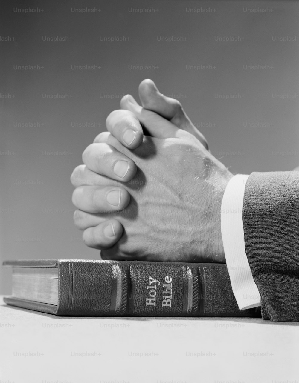 UNITED STATES - CIRCA 1960s:  Man's hands resting on top of holy bible, in prayer.