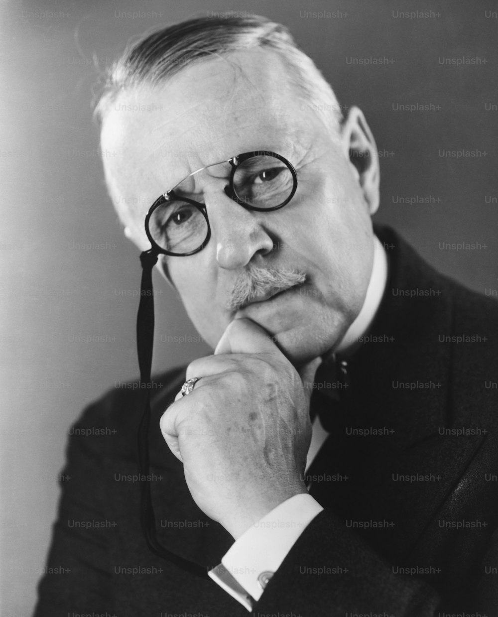 Una foto in bianco e nero di un uomo che porta gli occhiali