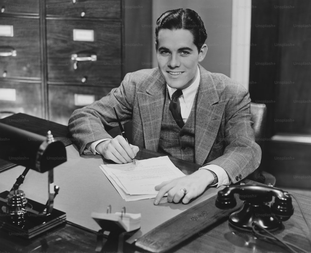 a man in a suit sitting at a desk