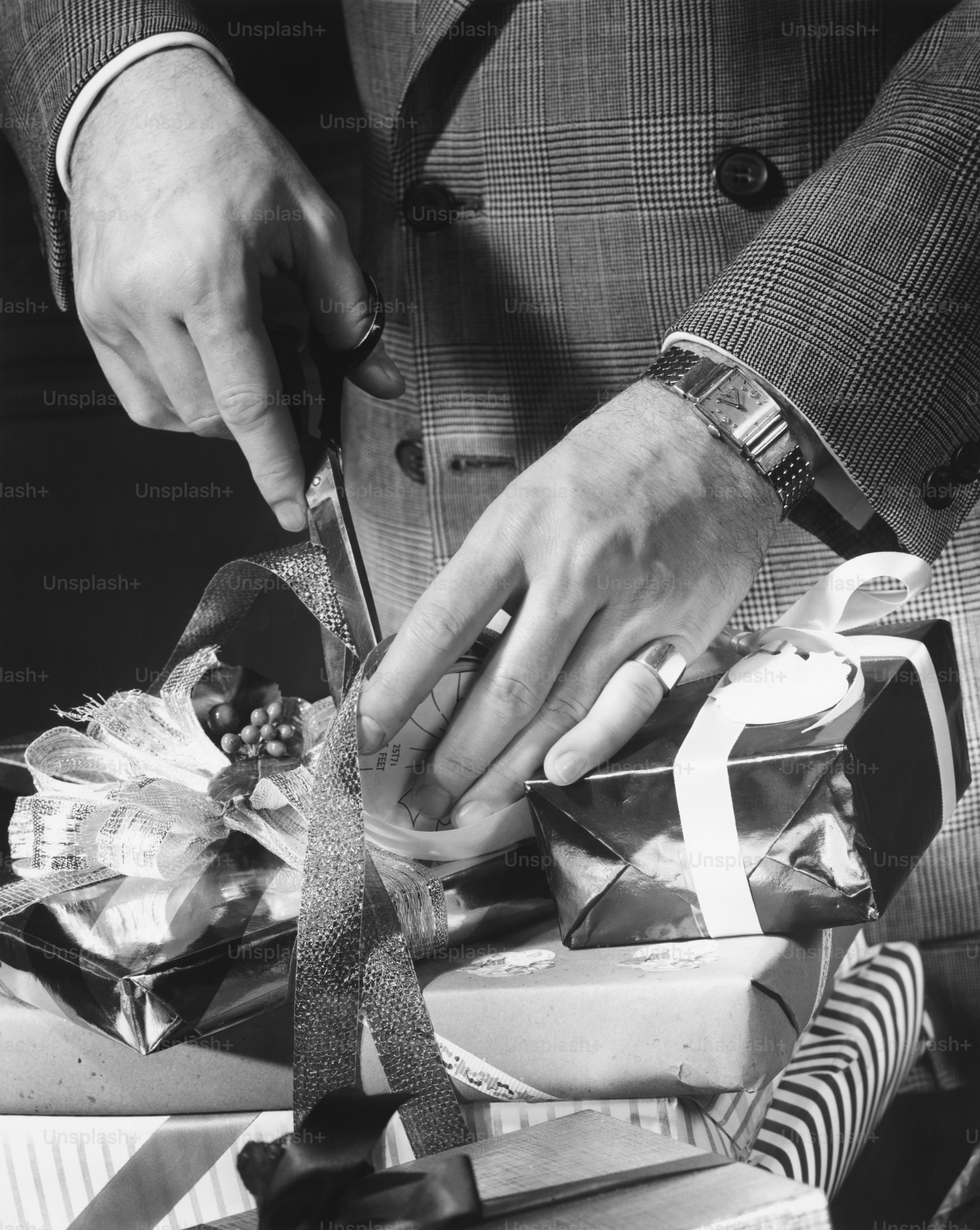 a person cutting a ribbon on a pile of presents