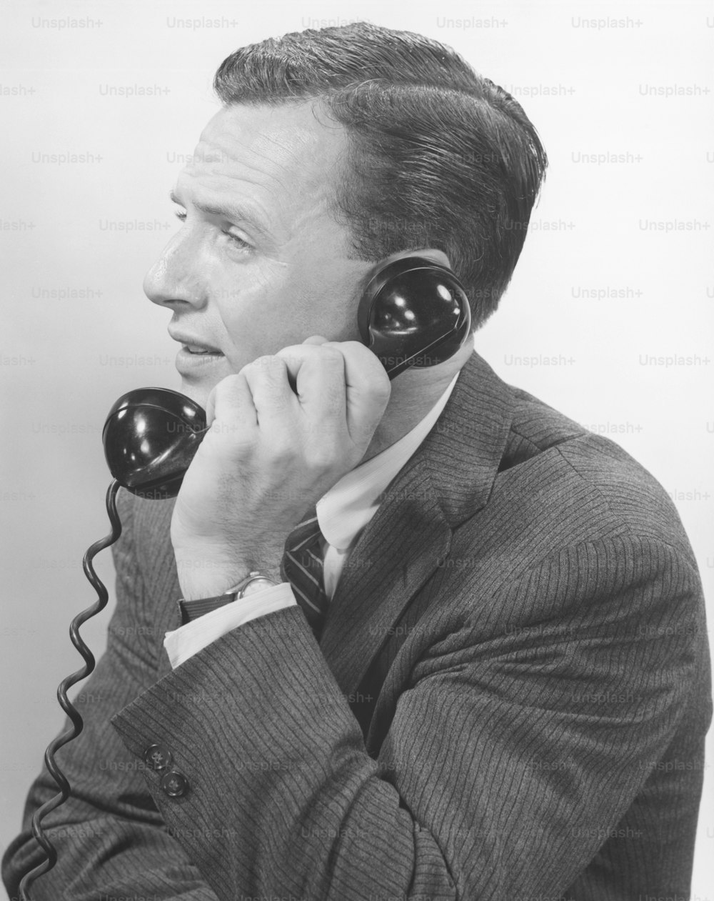 a man in a suit talking on a telephone