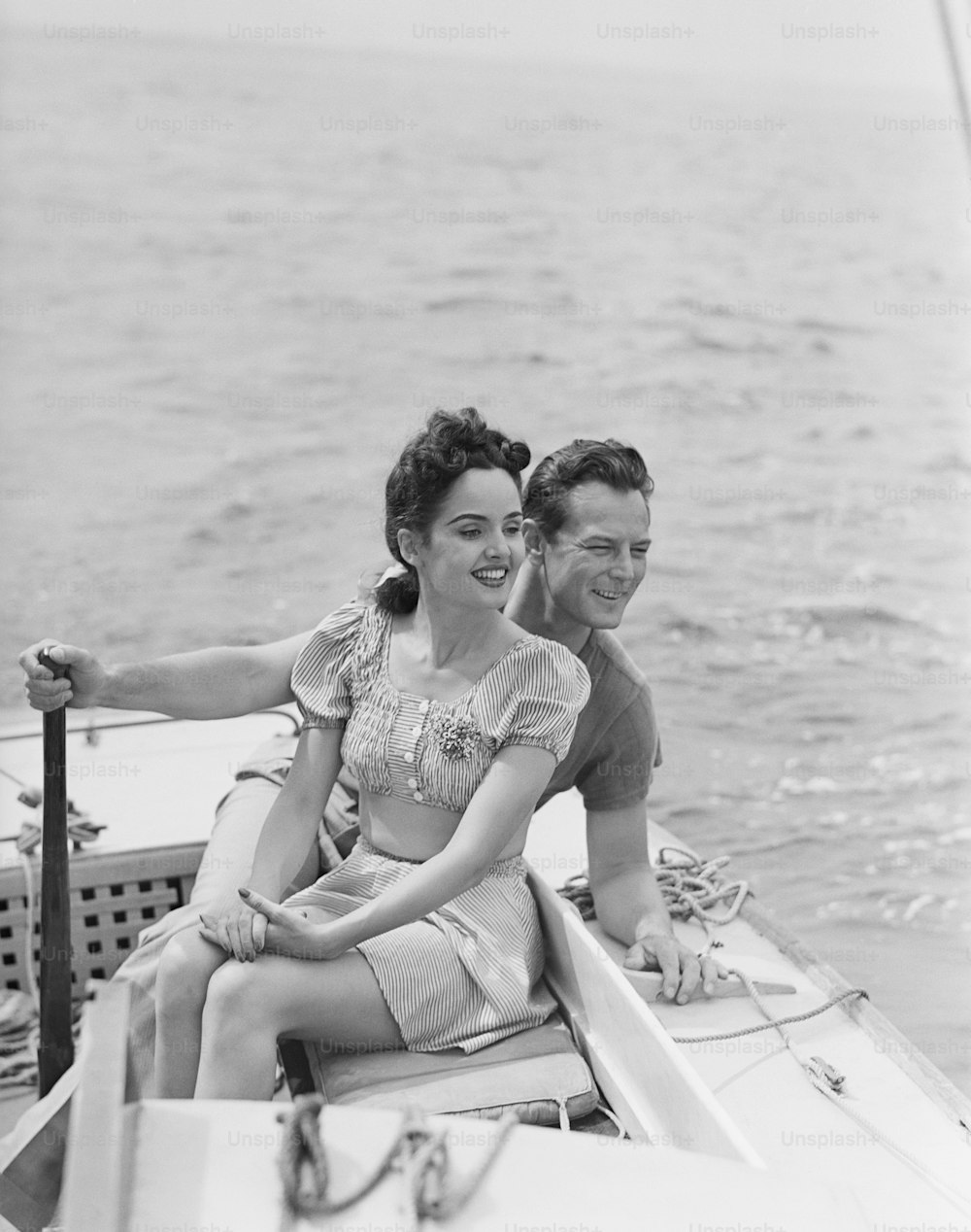 a black and white photo of a man and a woman on a boat
