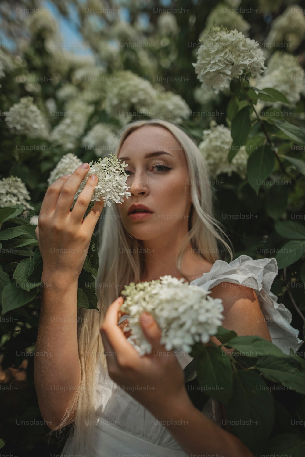 Una mujer sosteniendo un ramo de flores blancas
