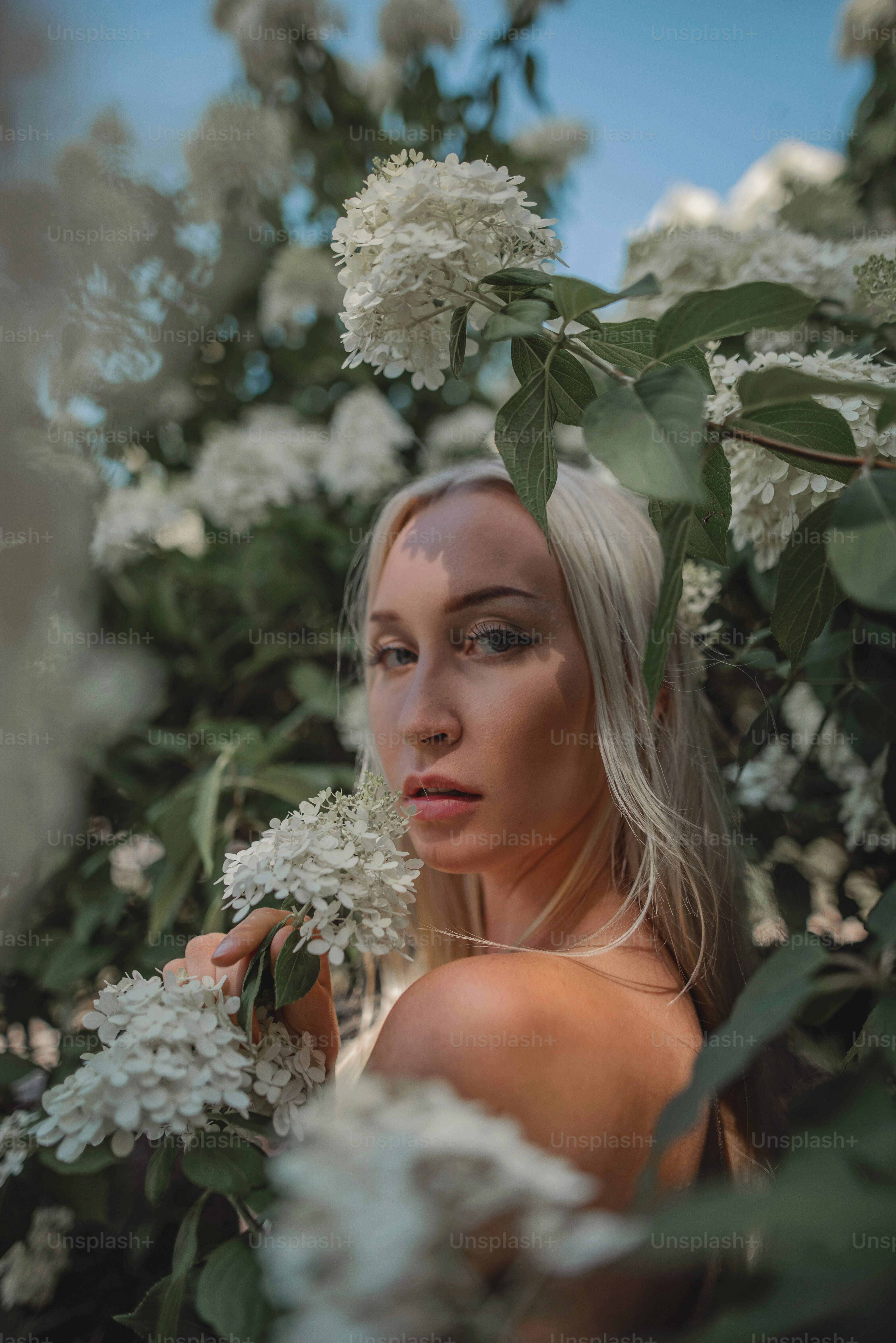 Une femme debout dans un champ de fleurs blanches