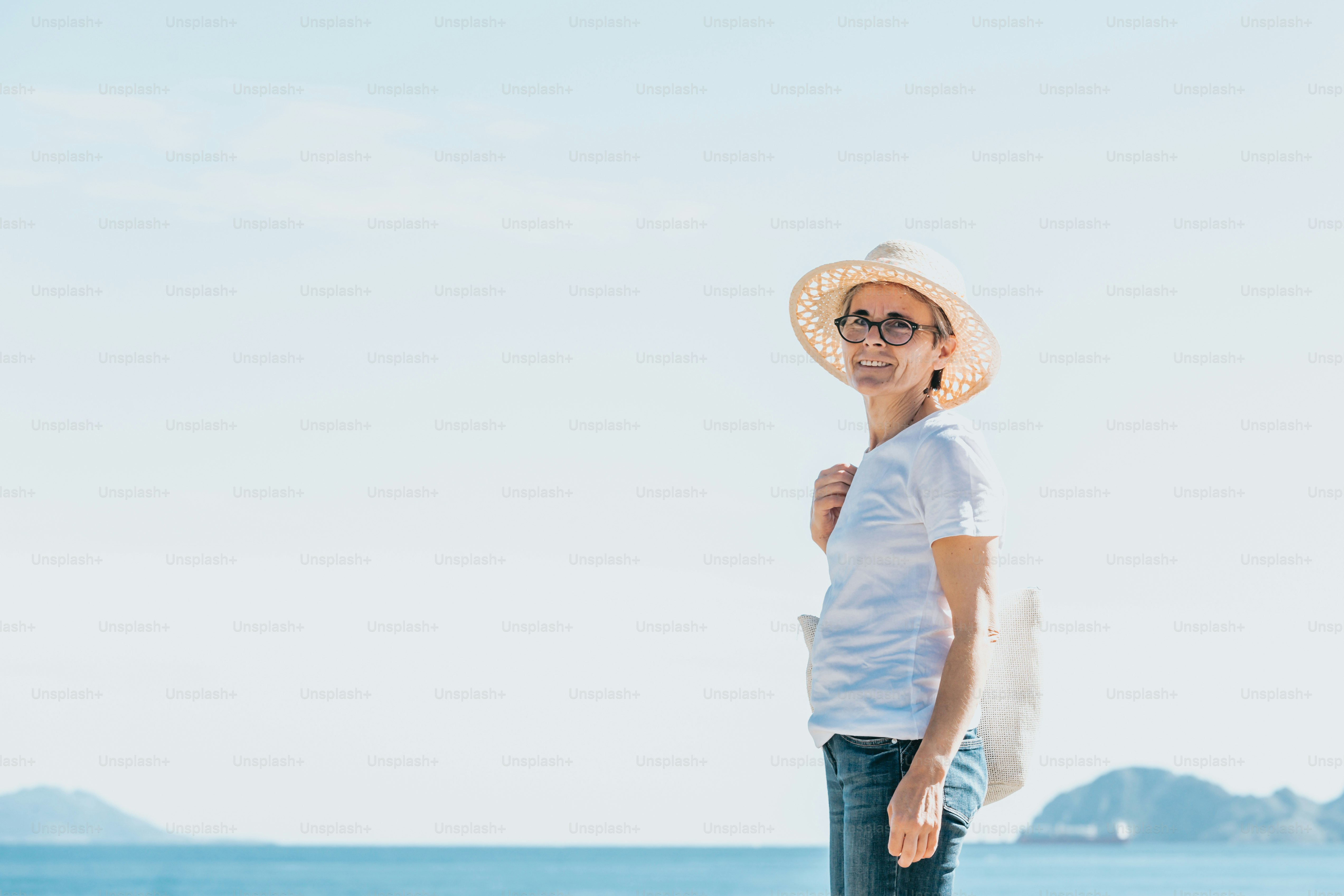 Eine Frau, die mit einem Hut am Strand steht