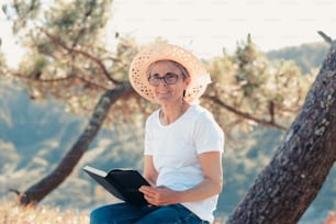 uma mulher usando um chapéu e lendo um livro