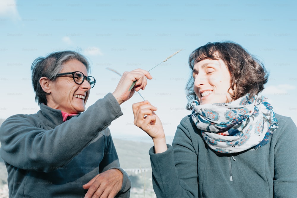 two women are smiling and one is holding a toothbrush