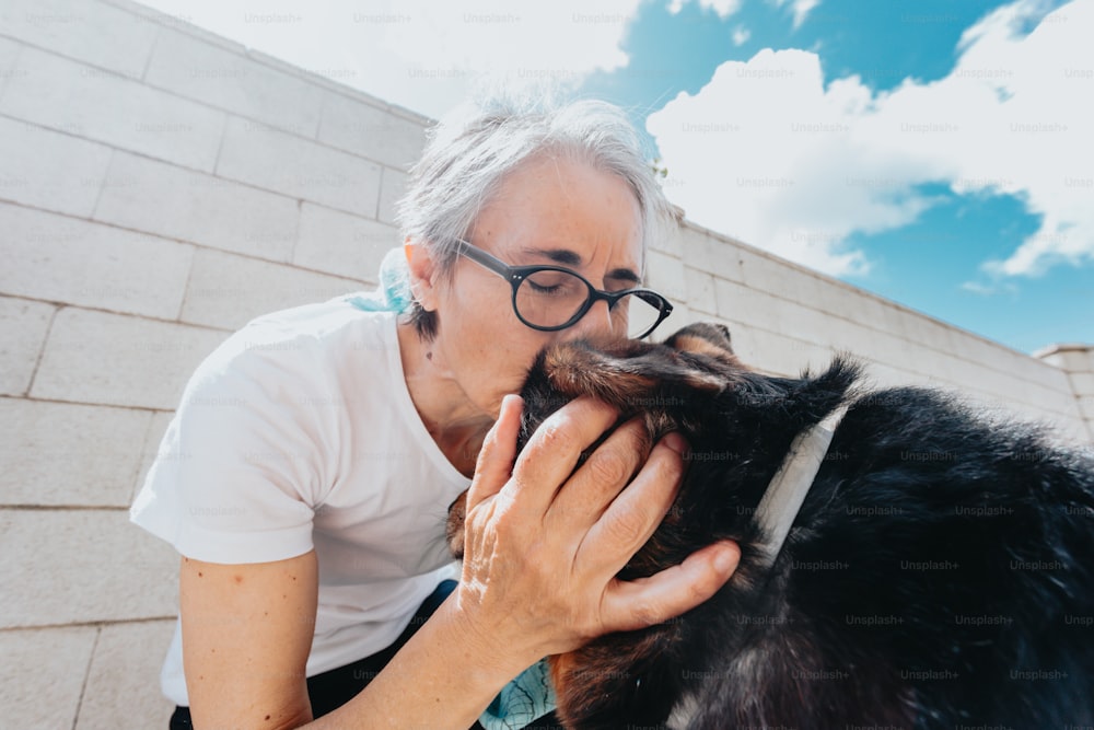 a woman is petting a dog outside