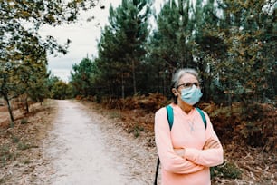 Une femme portant un masque facial debout sur un chemin de terre