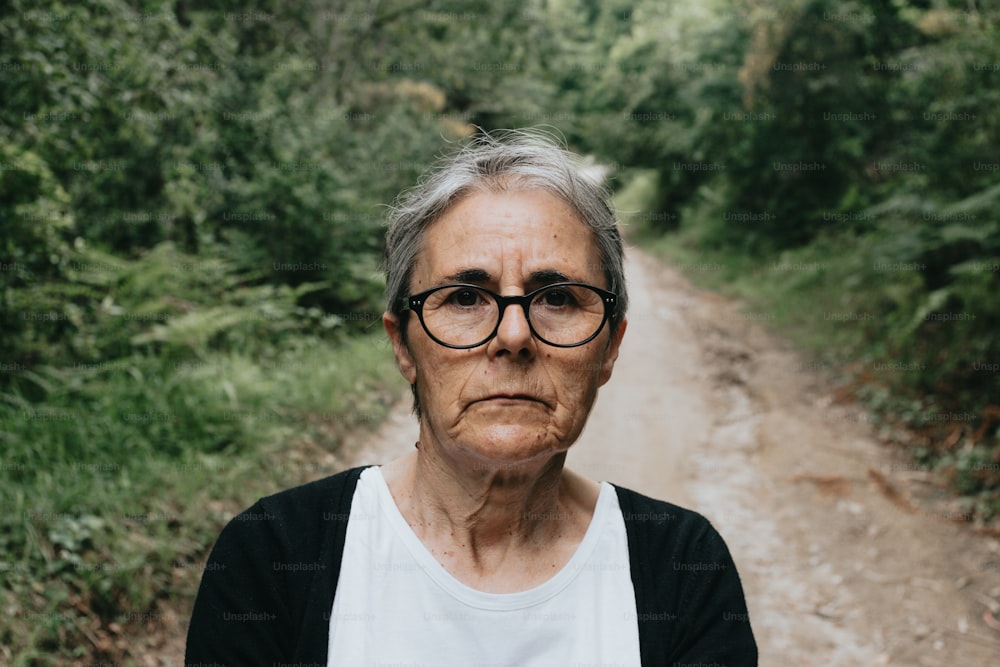 Eine Frau mit Brille, die auf einem Feldweg steht