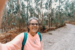 uma mulher tirando uma foto de si mesma na floresta