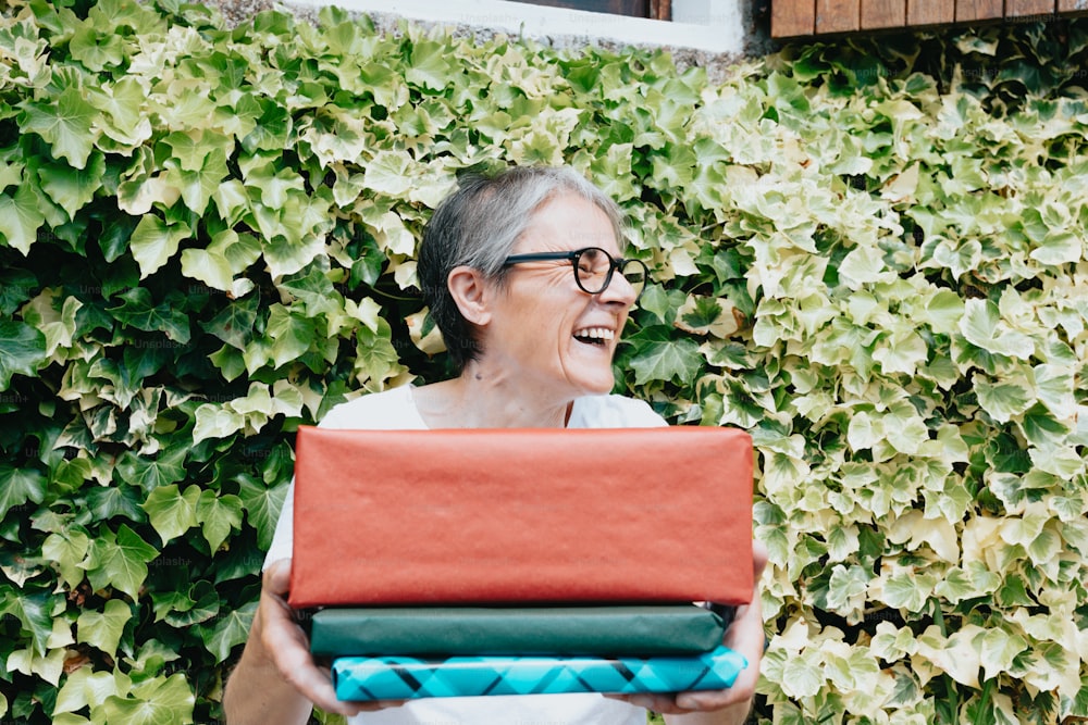 a woman holding a red and green case in front of a green wall