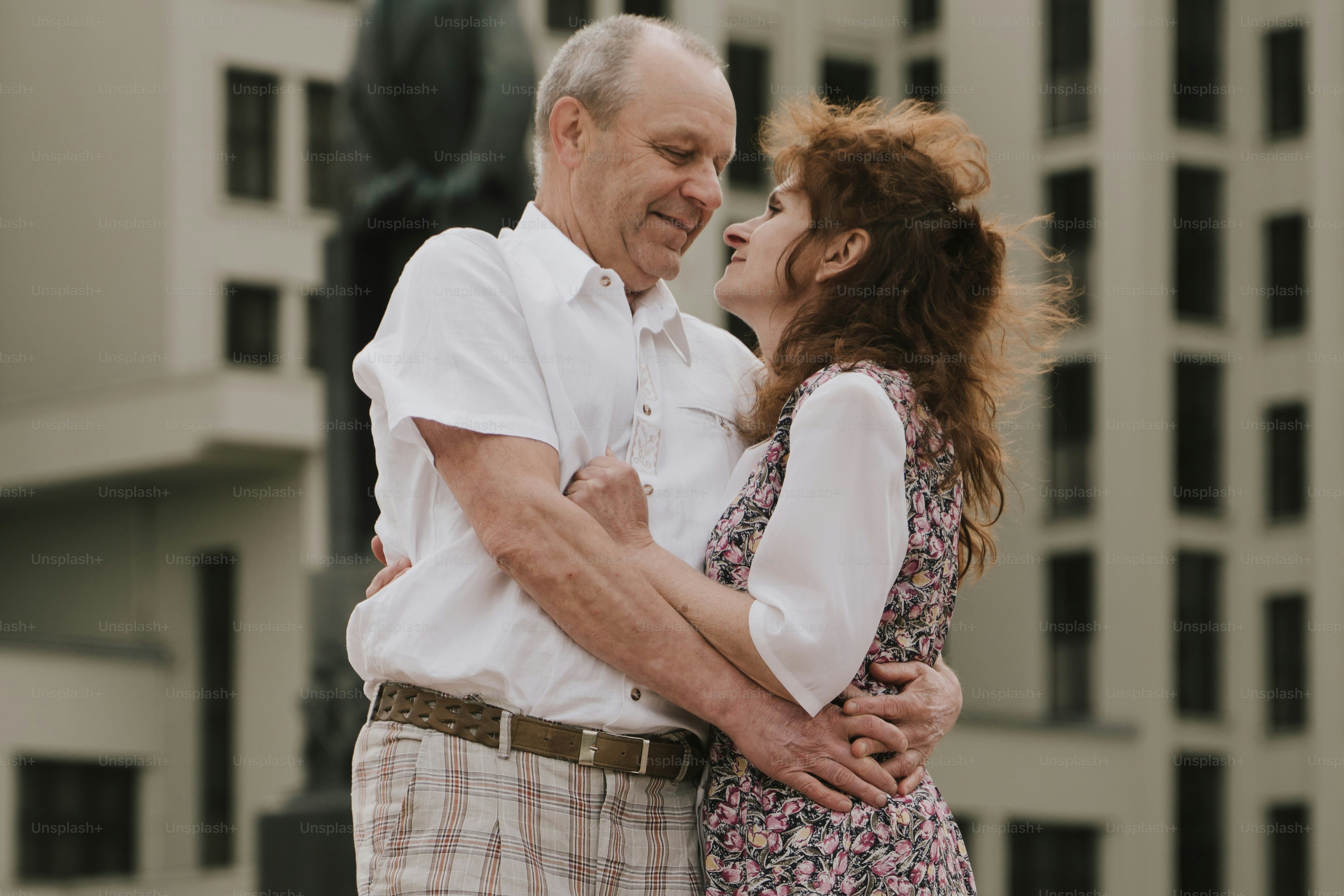 Un uomo e una donna che si abbracciano davanti a un edificio