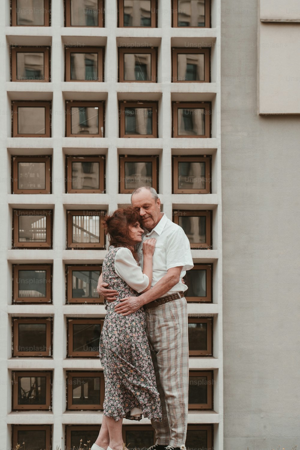 Un hombre y una mujer abrazándose frente a un edificio