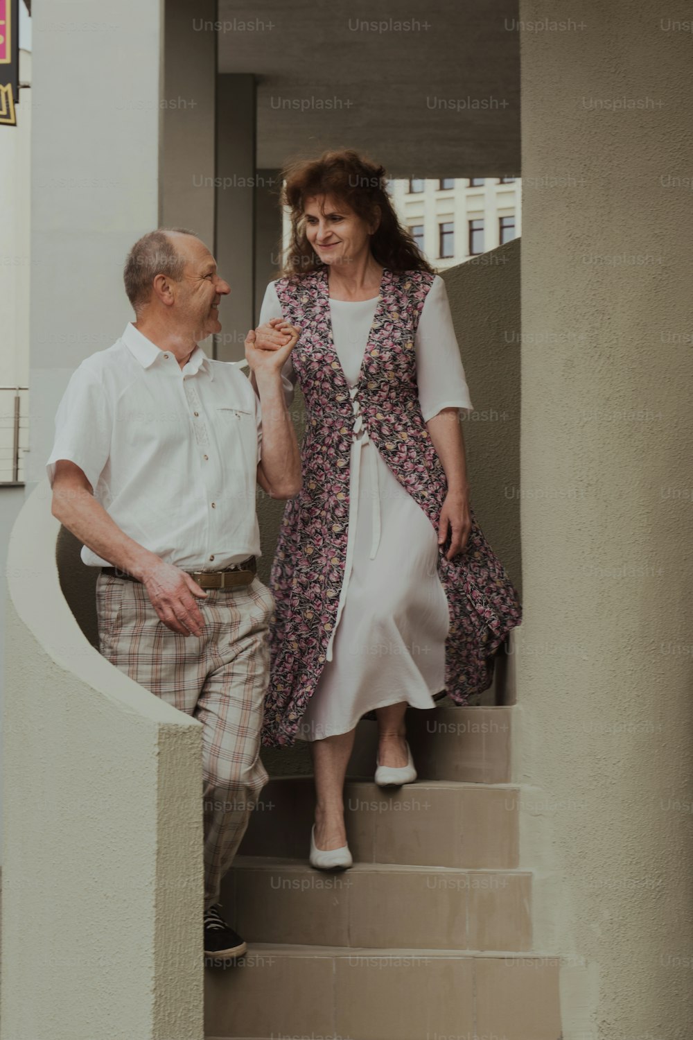 a man and a woman walking down a flight of stairs
