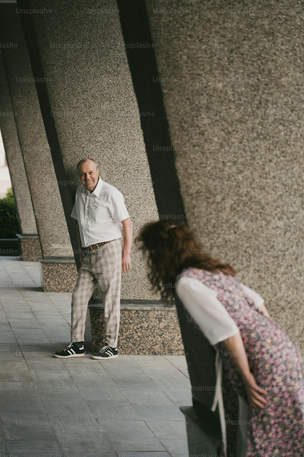 a man standing next to a woman on a sidewalk