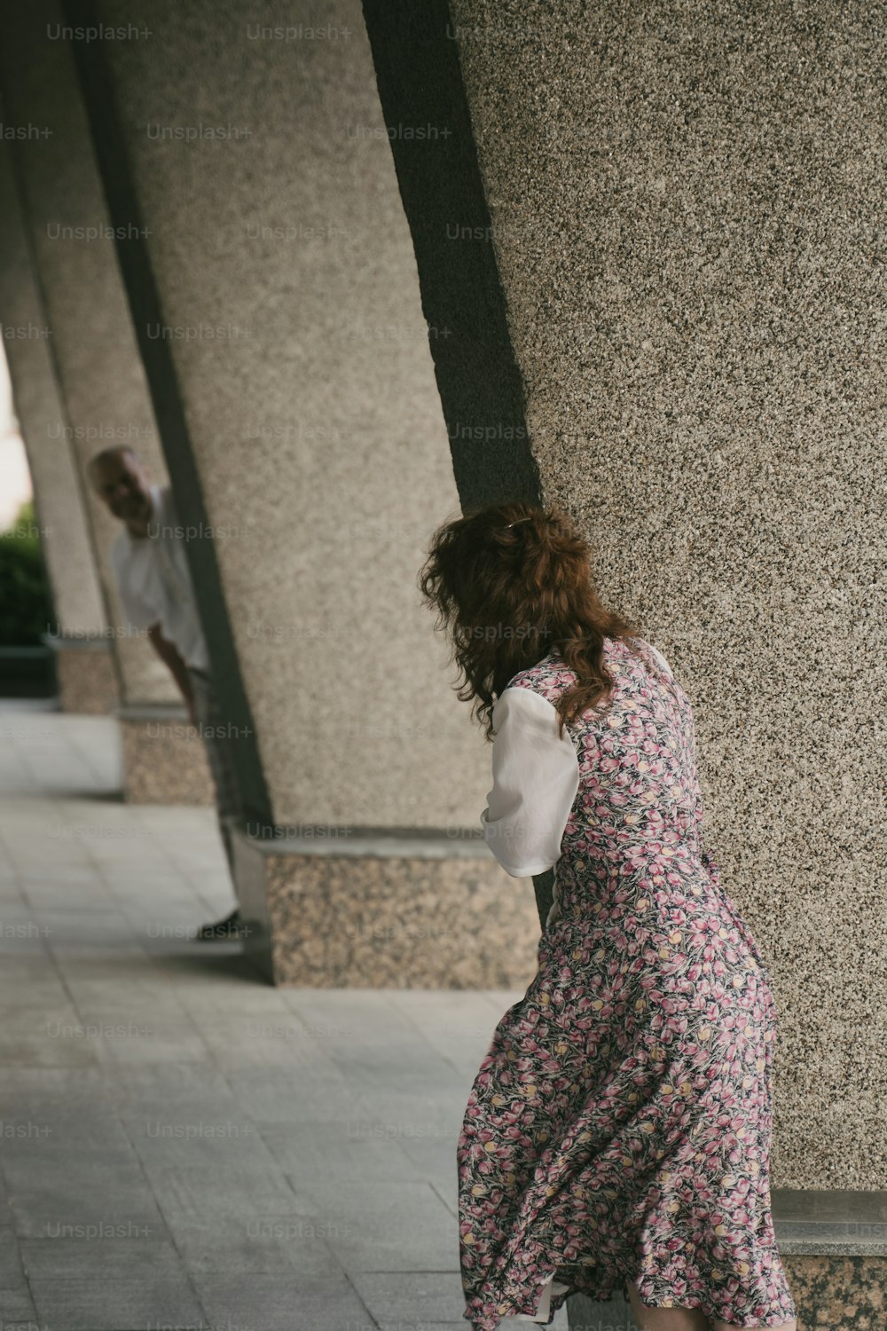 Eine Frau in einem Kleid, das an eine Wand gelehnt ist