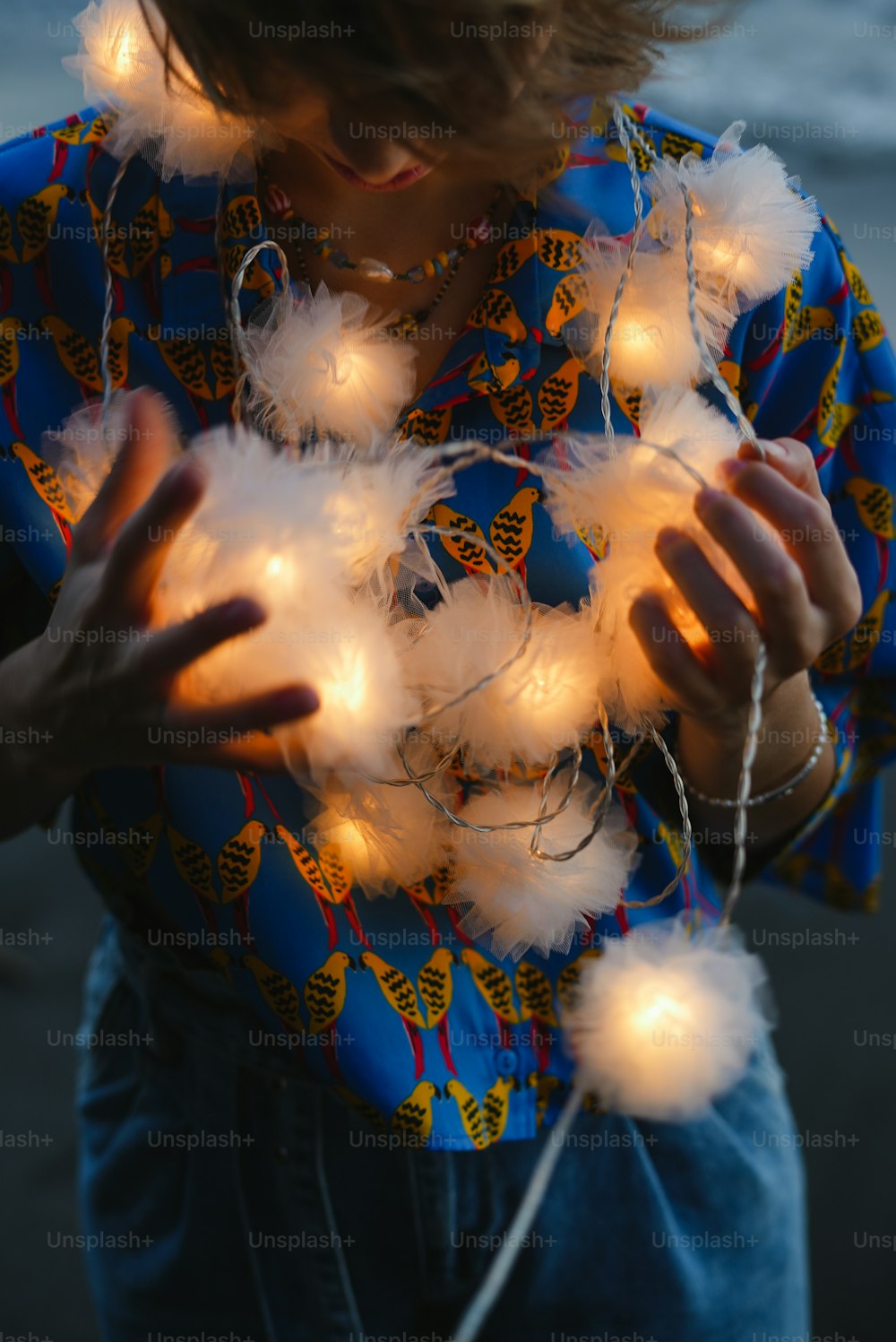 a woman holding a string of lights in her hands