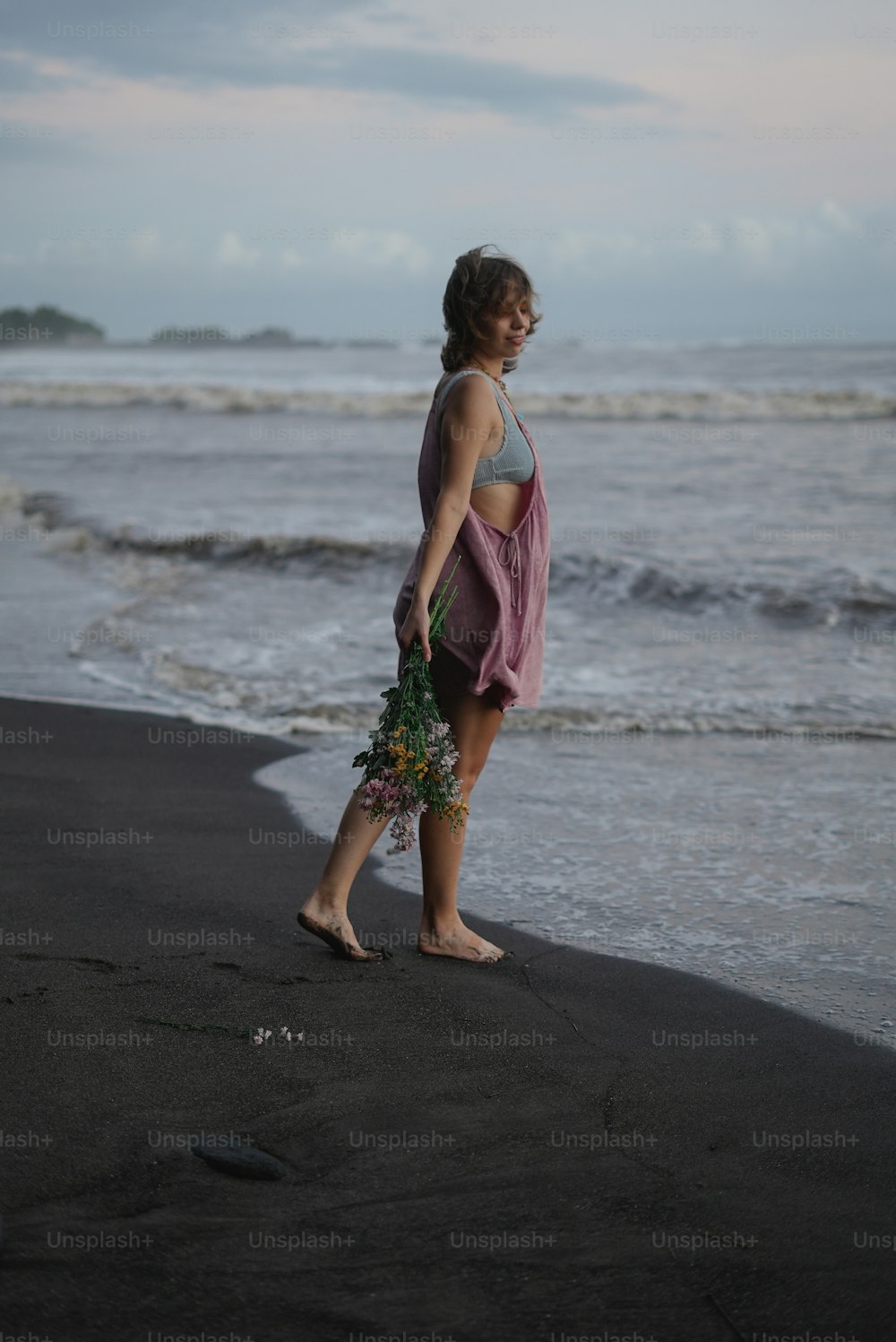 Una donna in piedi su una spiaggia vicino all'oceano