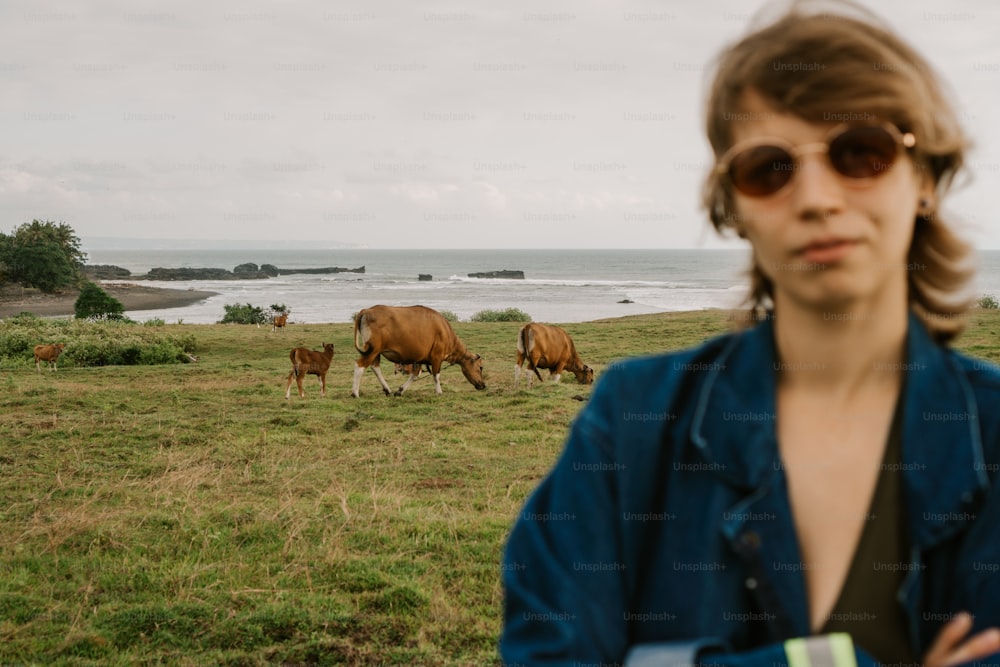 a woman standing in front of a herd of cows