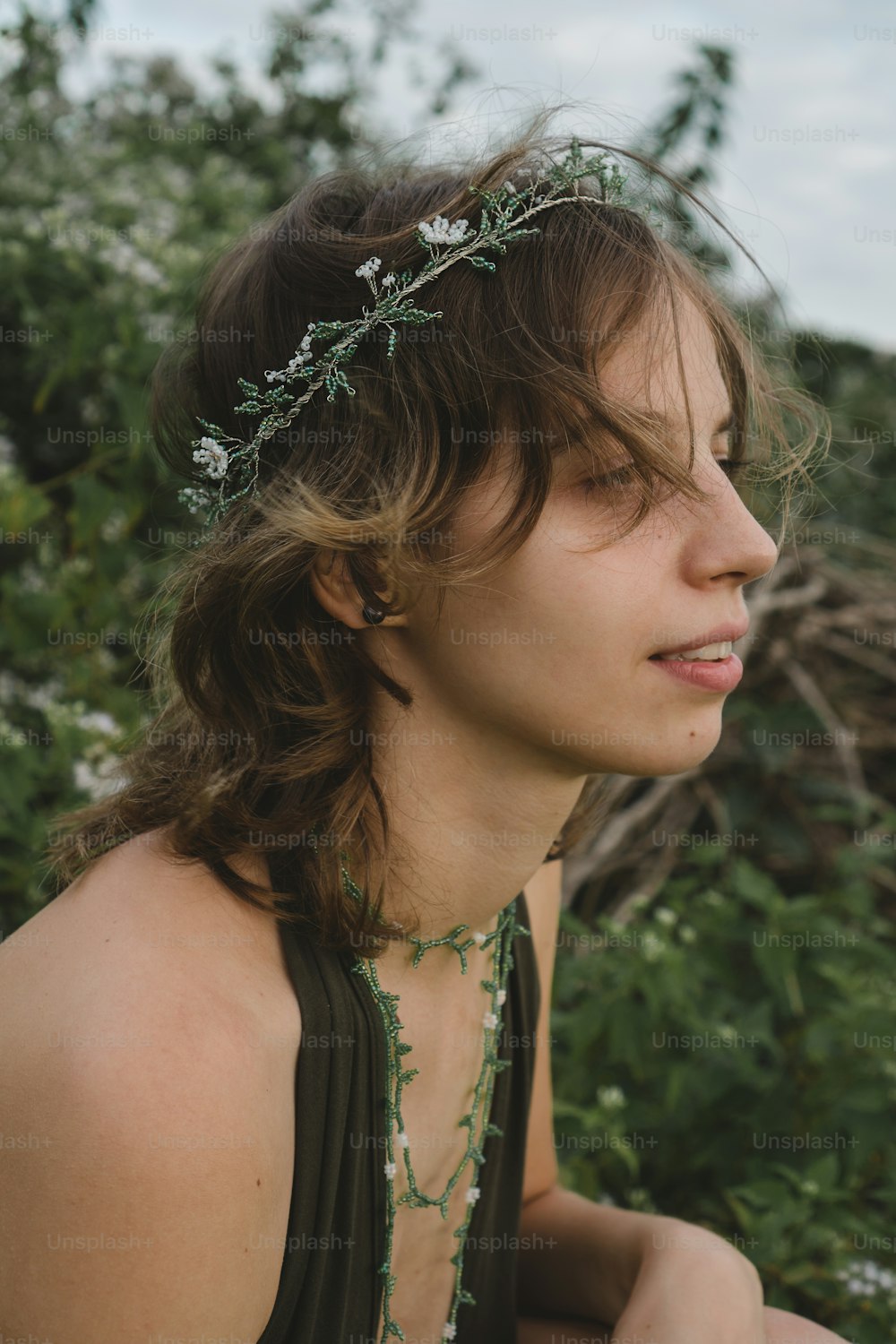 a woman wearing a necklace with flowers on it