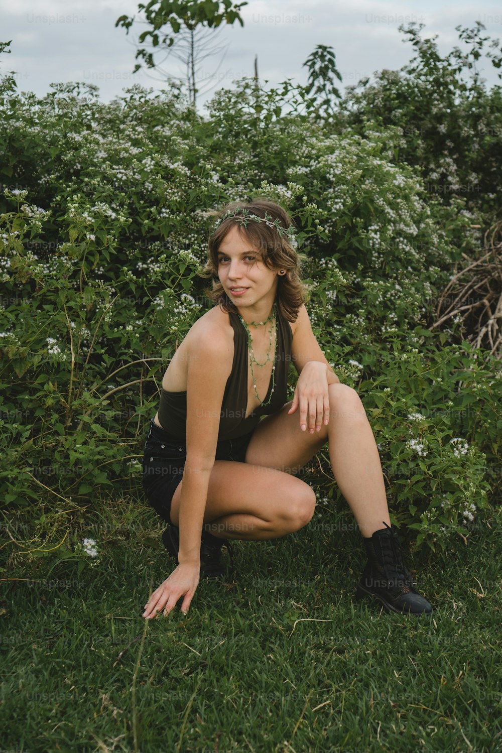 a woman kneeling down in a field of flowers