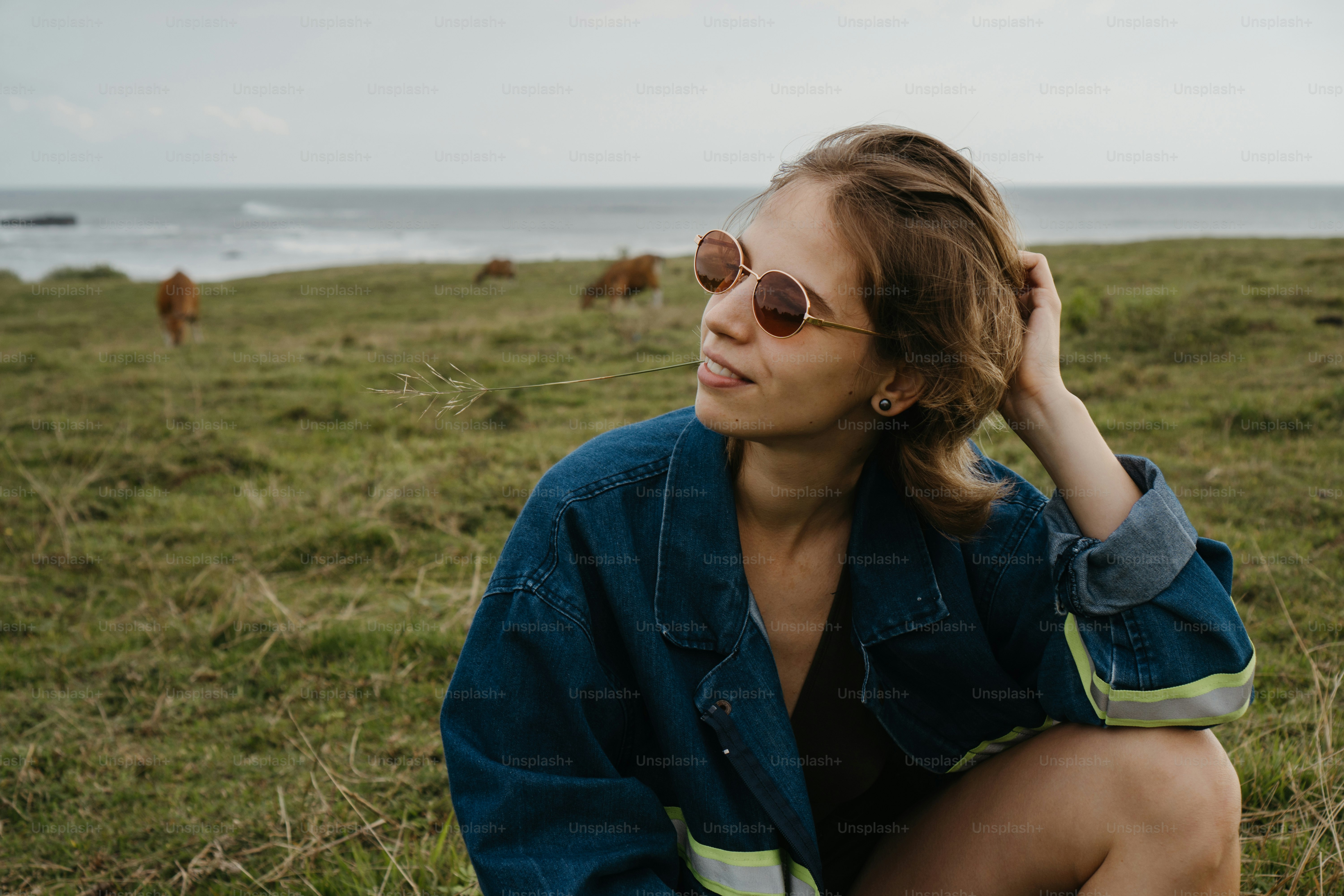 A woman sitting in the grass with her arms crossed photo – Woman Image ...