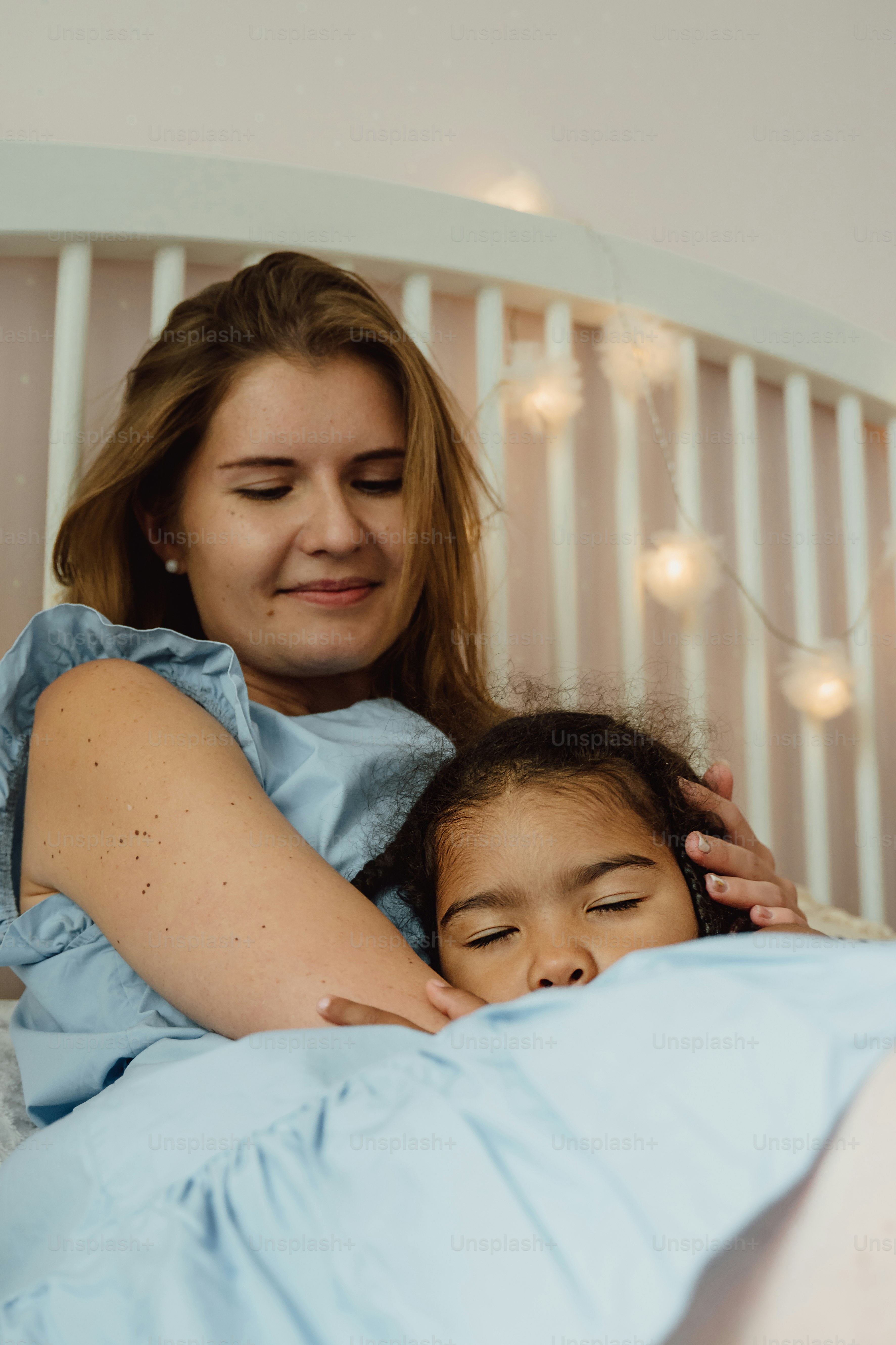 ベッドに横たわる女性と少女