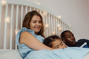 a woman laying in bed with two children