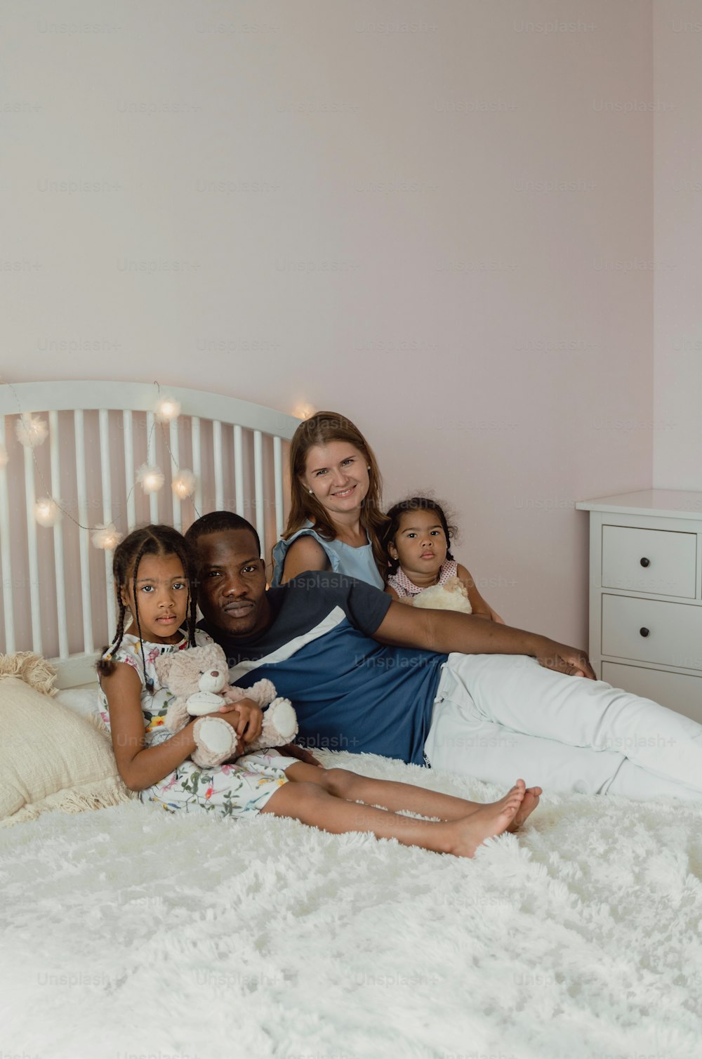 a woman and two children sitting on a bed