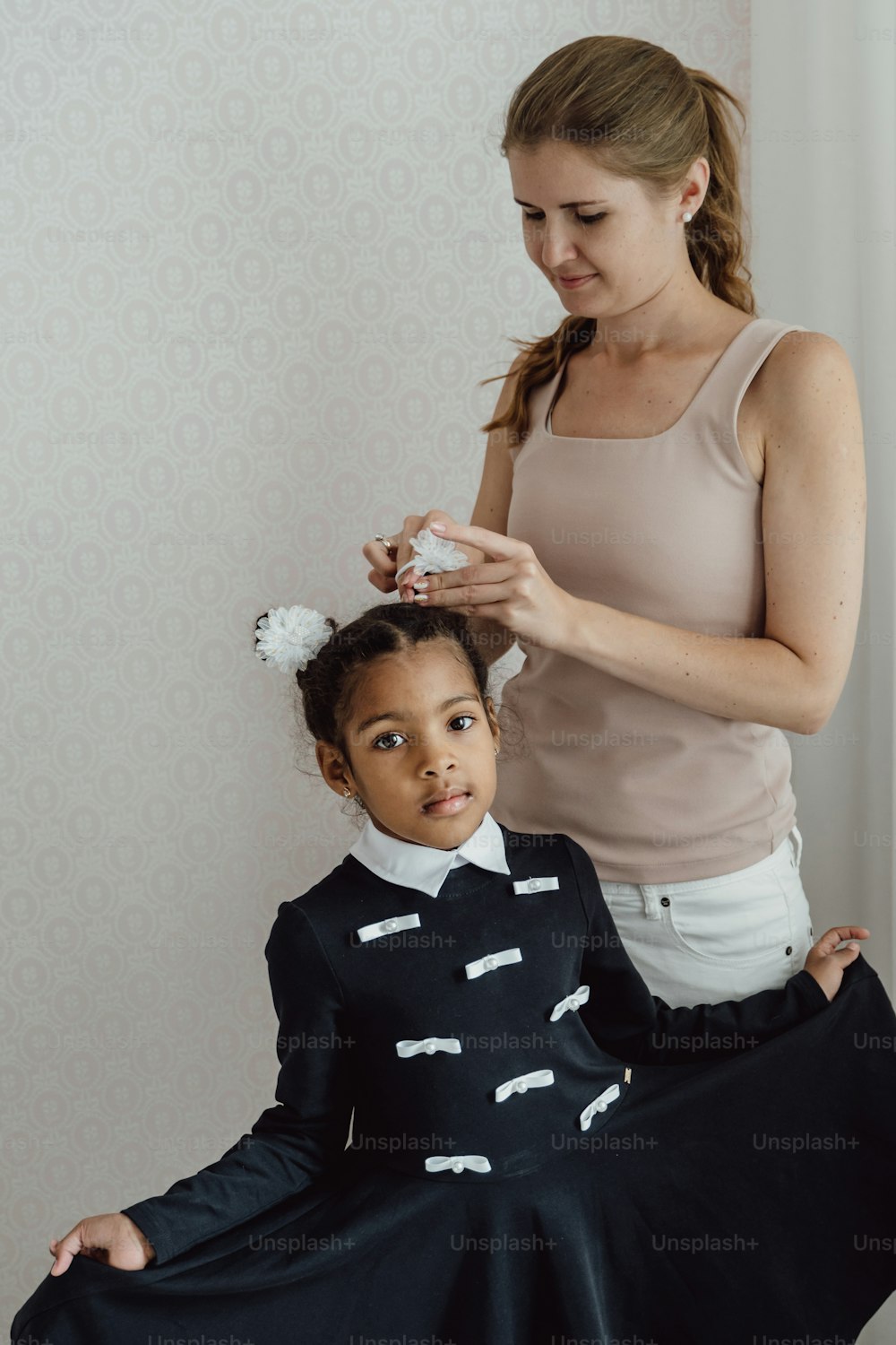 a woman is helping a little girl get her hair done