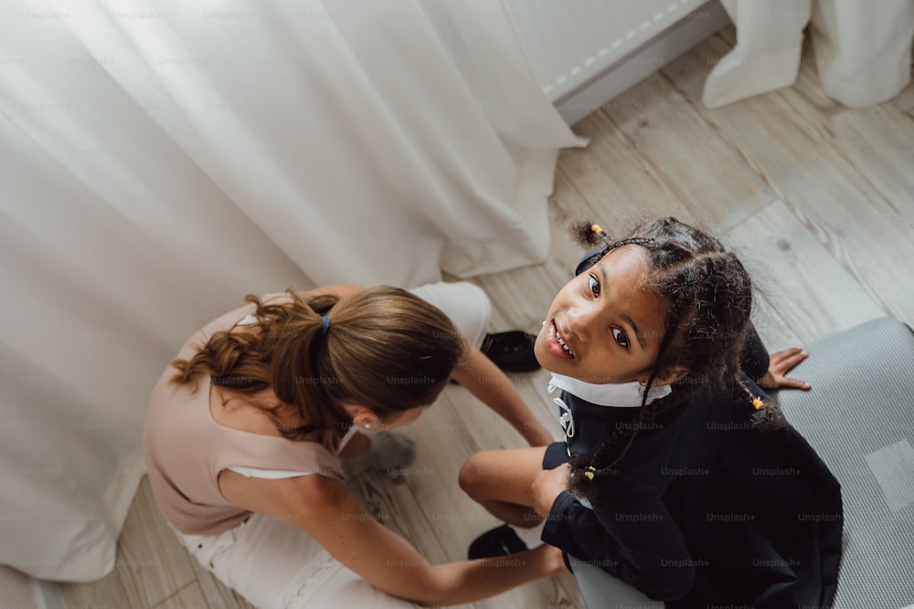 a woman kneeling down next to a little girl