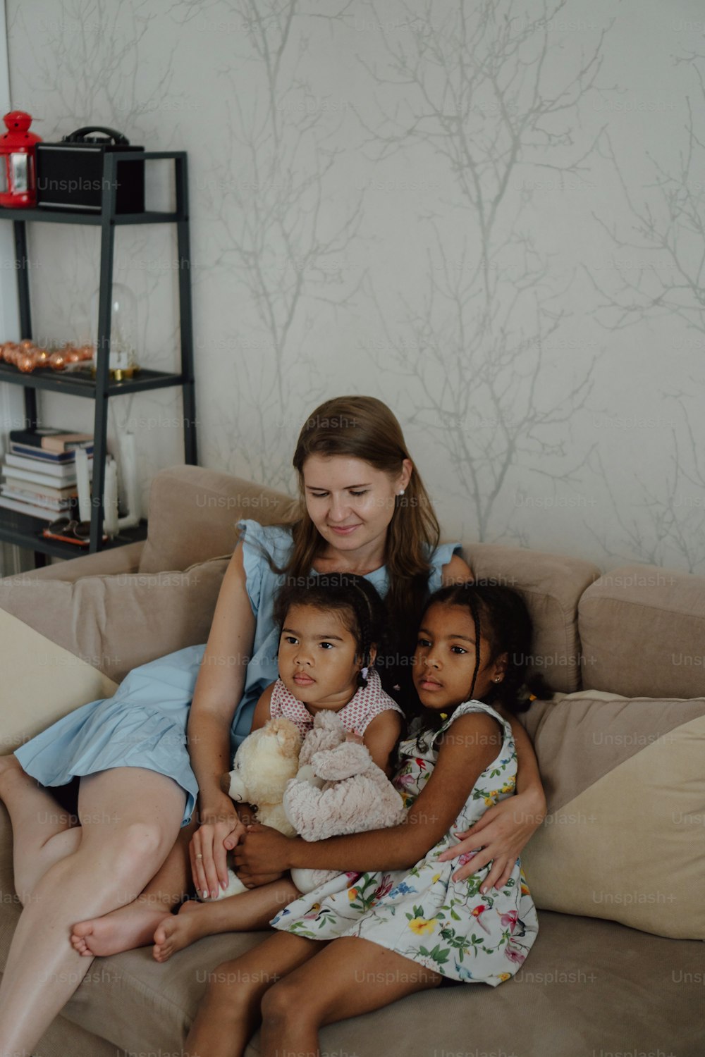 uma mulher sentada em um sofá com duas crianças